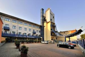duży budynek z samochodami zaparkowanymi na parkingu w obiekcie Blu Hotel - Sure Hotel Collection by Best Western w mieście Collegno
