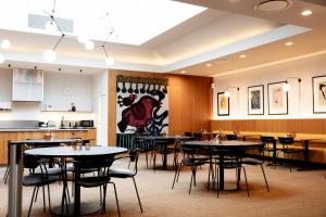 a restaurant with tables and chairs and a kitchen at Hotel Noreg in Ålesund