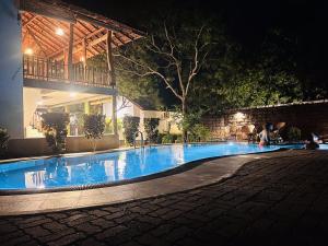 a swimming pool in front of a house at night at Yala Leopard Lodge in Yala