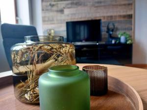 a green vase sitting on a table with a glass jar at Au Cerf & Fagnes in Spa