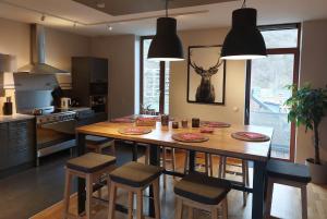a kitchen with a wooden table and some chairs at Au Cerf & Fagnes in Spa +23 photos