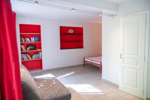 a living room with a couch and a red wall at La Magnanerie, 16 personnes avec piscine privée in Bagnols-sur-Cèze