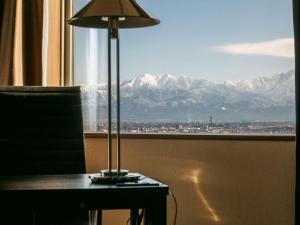 a lamp sitting on a table in front of a window at Oarks Canal Park Hotel Toyama in Toyama