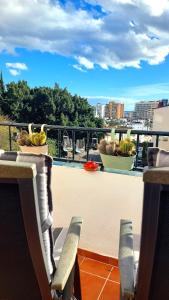 a balcony with chairs and a bowl of bananas on the ledge at Estudio PasoDoble. Pueblo Evita in Benalmádena