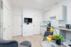 a kitchen and dining room with a table and chairs at Cozy 1 Bedroom apartment, 30 mins to Oxford street by tube C in London