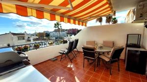 a patio with a table and chairs on a balcony at Estudio PasoDoble. Pueblo Evita in Benalmádena