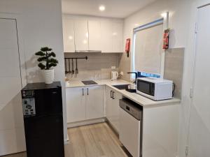 una pequeña cocina con nevera negra y microondas en Cosy Secure comfortable for two in Canberra, en Hall