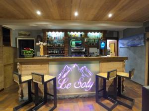 een bar met twee krukken en een bord dat zegt wees verlegen bij Hotel Le Soly in Morzine