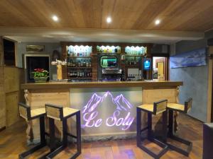 a bar with two stools and a sign that says be shy at Hotel Le Soly in Morzine