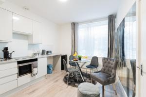 a kitchen with a table and chairs in a room at Cozy 1 Bedroom apartment, 30 mins to Oxford street by tube C in London