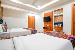 a hotel room with two beds and a television at FabHotel Nobel Inn in Ahmedabad