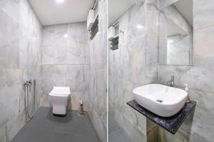 uma casa de banho com um lavatório e um WC em FabHotel Nobel Inn em Ahmedabad