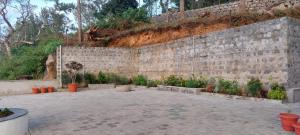 a stone retaining wall with plants in a courtyard at HillTop in green meadows yercaud in Yercaud