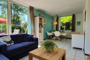 a living room with a blue couch and a table at Bungalowpark Mooyeveld in Egmond-Binnen