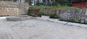 a courtyard with a stone wall and a stone patio at HillTop in greany meadows yercaud in Yercaud