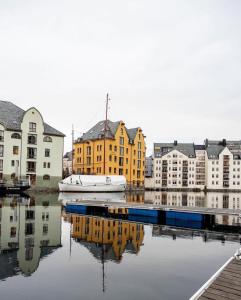 Hotel Noreg في أوليسوند: ميناء فيه مباني وقارب في الماء