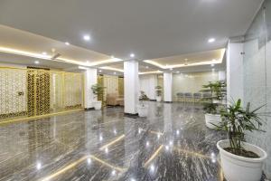 a large lobby with potted plants and chairs at Limewood Stay - Millennium Huda city center in Gurgaon