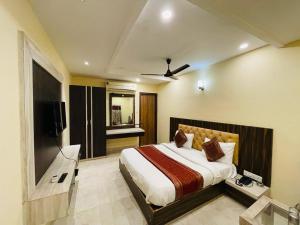 a bedroom with a bed and a flat screen tv at HOTEL AUGUSTO in Varanasi