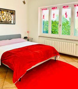 ペルレードにあるLe Palme House Rifugio Romantico & late check-outのベッドルーム1室(窓のあるベッド1台、赤い毛布付)