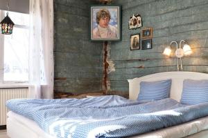 Ralph Lundstengården (Farmhouse Lodge) في لوليا: غرفة نوم عليها سرير وبطانية زرقاء