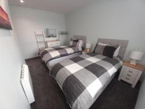 a bedroom with two beds and a mirror at 19a Francis Street in Stornoway