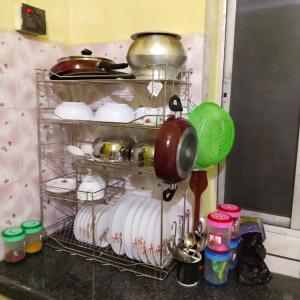 a rack full of dishes and pots and pans at Piyari home stay in Kolkata