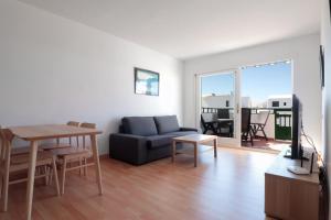 a living room with a couch and a table at Apartamento recién reformado en la playa in Costa Teguise