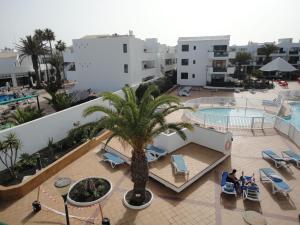 an aerial view of a hotel with a palm tree at Apartamento recién reformado en la playa in Costa Teguise