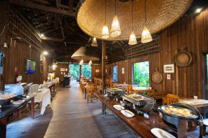 un restaurante con paredes de madera, mesas y sillas en Eco Resort Chiang Mai, en Chiang Mai