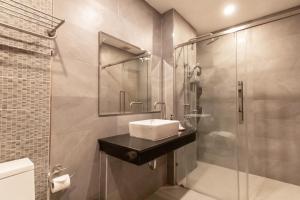 a bathroom with a sink and a shower at Ananzitra Hotel in Kanchanaburi