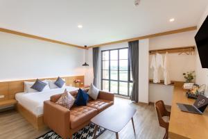 a hotel room with a bed and a couch at Ananzitra Hotel in Kanchanaburi