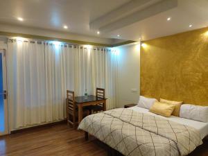 - une chambre avec un lit et une table avec un bureau dans l'établissement Evaan's Casa Homestay, à Alappuzha