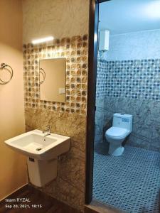 La salle de bains est pourvue d'un lavabo et de toilettes. dans l'établissement Evaan's Casa Homestay, à Alappuzha