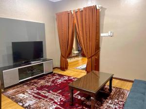 un soggiorno con TV, divano e tavolo di Rumah Tok Wan Dee (House 4 Rooms) 2024 a Wakaf Baharu