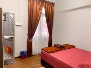 um quarto com uma cama vermelha e uma janela em Rumah Tok Wan Dee (House 4 Rooms) 2024 em Wakaf Baharu