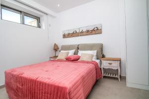 a bedroom with a bed with a pink comforter at Francis & Gregorys Luxury Villas in Afantou
