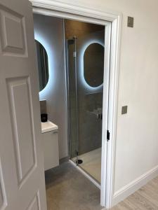 a bathroom with a shower with a glass door at Luxury Kingsize Room in London in Catford