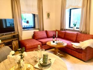 巴特尚道的住宿－Sonnenhof Bad Schandau，客厅配有红色的沙发和桌子