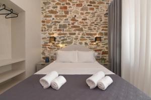 a bedroom with a bed with three towels on it at Alesio's house in Ermoupoli