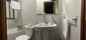 uma casa de banho branca com um WC e um lavatório em Hostal Los Amigos em Siruela