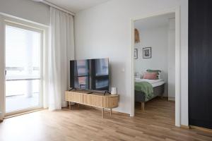 a living room with a television and a bed at Saunallinen uudiskohde Logomon vieressä, ilmainen autohallipaikka + Wi-Fi in Turku