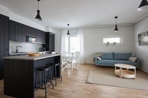 a kitchen and a living room with a blue couch at Saunallinen uudiskohde Logomon vieressä, ilmainen autohallipaikka + Wi-Fi in Turku
