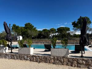einen Pool mit Stühlen und Sonnenschirmen vor einem Pool in der Unterkunft Vila Olson - Holiday Village Twins in Pakoštane
