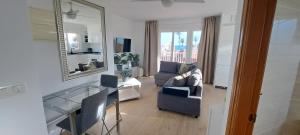 - un salon avec un canapé et une table en verre dans l'établissement Mazarron Beach apartment, à Mazarrón