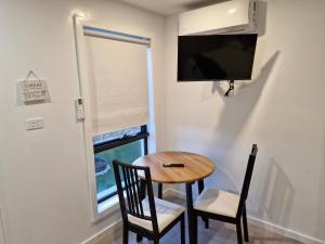 HallCosy Secure comfortable for two in Canberra的一张带两把椅子的小型餐桌和一台电视
