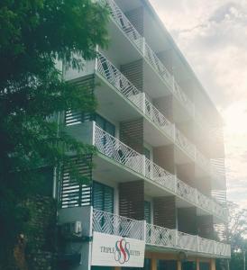 ein weißes Gebäude mit einem Schild davor in der Unterkunft Triple 8 Suites in Labuan Bajo