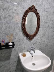 baño con lavabo y espejo en la pared en Wonthaggi en Amritsar