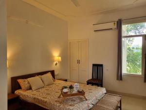 a bedroom with a bed with a table and a window at Wonthaggi in Amritsar