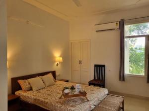 Un dormitorio con una cama con una mesa y una ventana. en Wonthaggi, en Amritsar