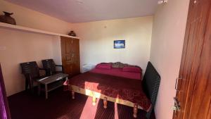 1 dormitorio pequeño con 1 cama y 1 silla en Bagheecha Homestay, en Kanatal